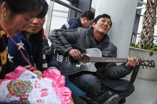 1月28日，上海虹桥机场，来自云南傈僳族的7位农民工坐在机场候机，他们弹着吉他唱起家乡的歌曲。