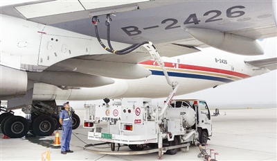 图为机场地勤人员在为客机加装航空煤油